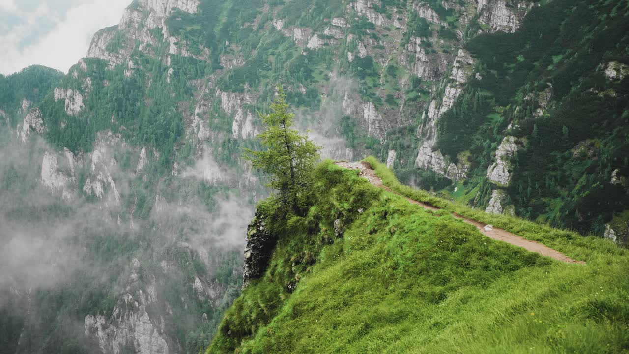 cámara lenta de zoom estático de un punto de vista panorámico en la montaña caraiman, un camino de senderismo empinado que cruza valles profundos y paredes rocosas verticales en las montañas bucegi carpatas