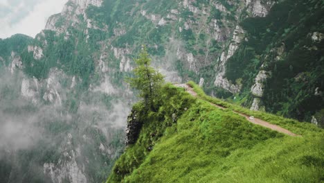 Slow-motion-static-zoom-in-shoot-of-a-panoramic-viewpoint-on-Caraiman-Mountain,-a-steep-hiking-pathway-crossing-deep-valleys-and-vertical-rock-walls-in-the-Bucegi-Carpathian-Mountains