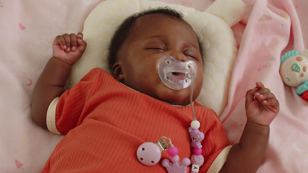 Black Baby Girl Lying in Bed with Eyes Closed
