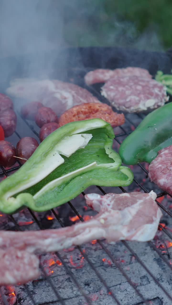 Various meats and bell peppers grilling on a barbecue