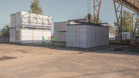 toma de tiempo de la grúa levantando y colocando una sala de contenedores blanca sobre un camión para el transporte durante el día