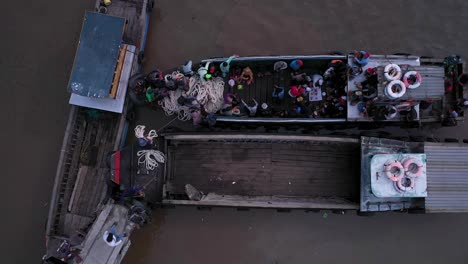 Aerial-view-of-maritime-workers-boarding-small-boats-at-Saigon-River-jetty,-Vietnam