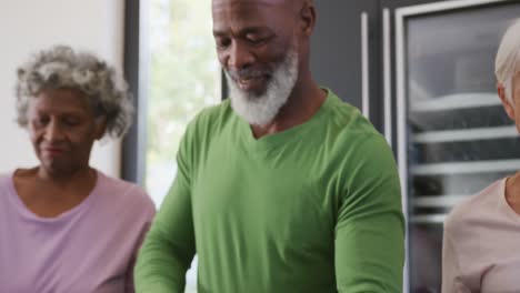 Happy-senior-diverse-people-cooking-in-kitchen-at-retirement-home