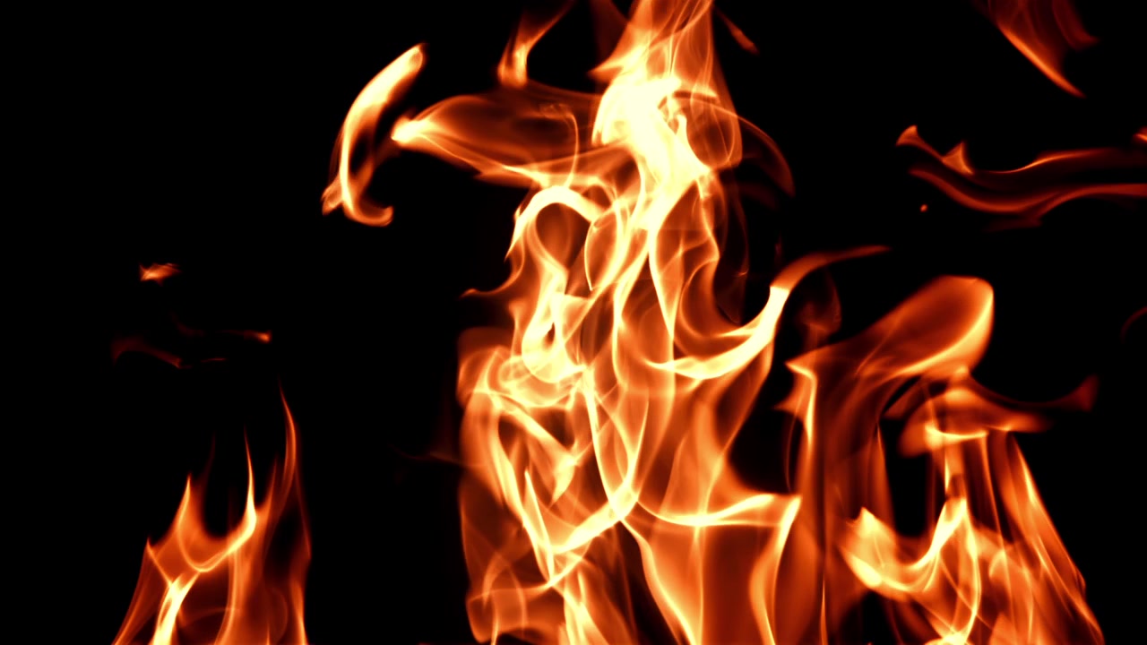 Fiamme vivaci arancioni e gialle che bruciano su sfondo nero