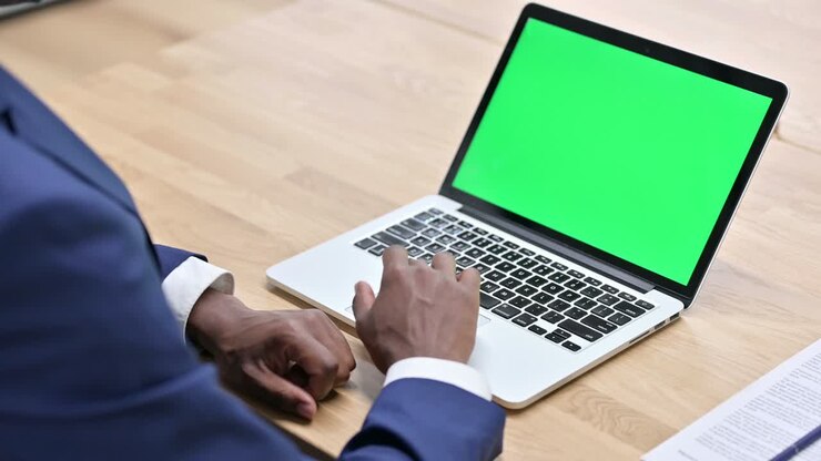 Homme africain utilisant un ordinateur portable avec écran vert.