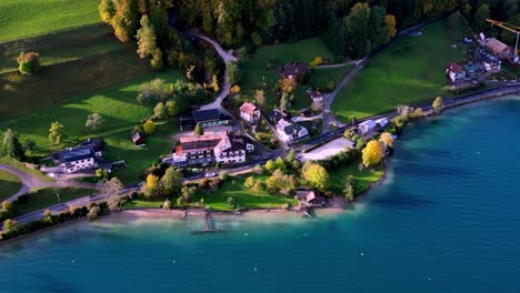 Peaceful-aerial-view-of-a-small-town-nestled-next-to-a-sparkling-lake