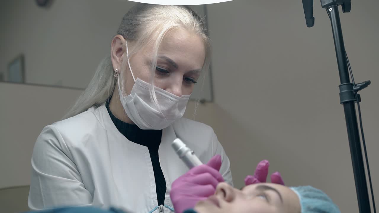 woman in black pullover applies permanent eyebrow make-up