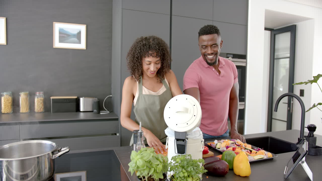 Preparando refeição saudável com vegetais frescos, casal cozinhando junto em cozinha moderna
