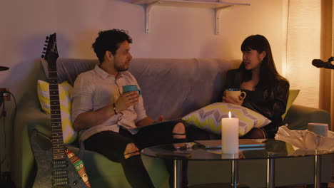 Couple Relaxing at Home with Drinks and Music