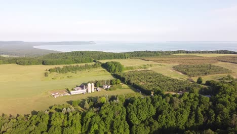 Scenic-View-Of-The-Lush-Cherry-Orchard-With-Pyramid-Point-In-The-Background-At-The-Sleeping-Bear-Dunes-National-Lakeshore,-Leelanau-County,-Michigan---aerial