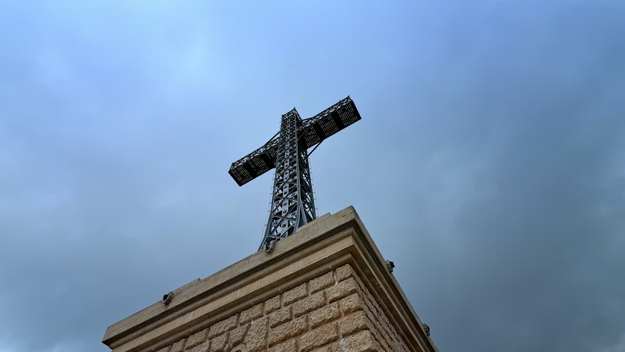 Caraiman Cross monument against cloudy sky. Monumental metal Caraiman Cross rising against dramatic sky in the Bucegi Mountains