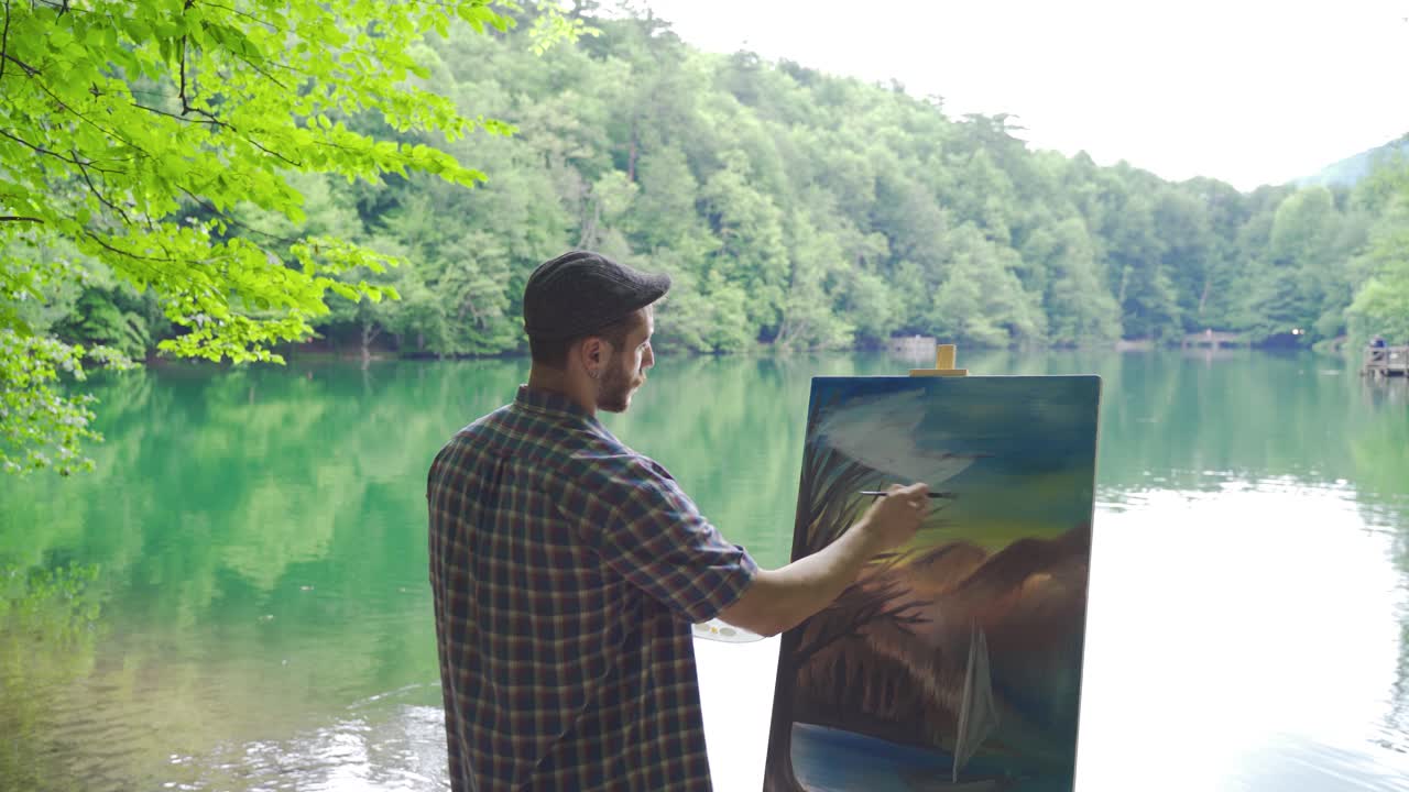 Painter paints a picture by the lake.
