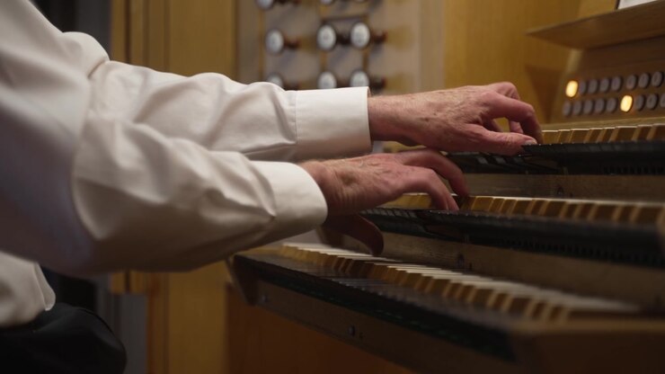 Hands of a master playing a pipe organ - isolated on the keys