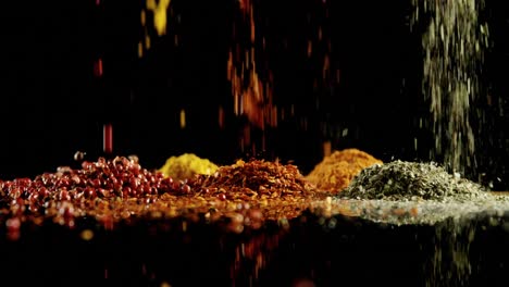 herbs and spices falling on black surface 4k