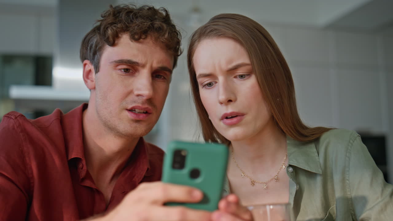 Tensed husband looking smartphone drinking coffee in kitchen frustrated closeup