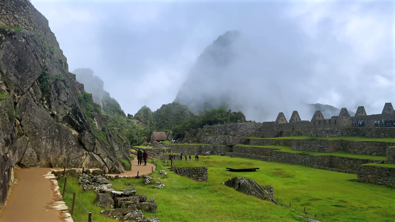 Szlak turystyczny Machu Picchu słoneczne niebo chmury poranek Peru Perú góra Huayna Picchu pora deszczowa bujna zieleń peruwiańskie Andy Świątynia Inków Sanktuarium dżungla kamienne konstrukcje taras ruch do przodu