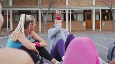 Diverso-Equipo-De-Baloncesto-Femenino-Sentado-En-El-Suelo-Y-Hablando