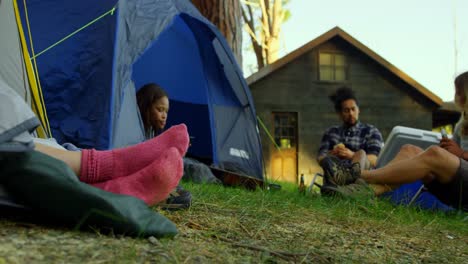 Friends-relaxing-near-tent-in-the-forest-4k