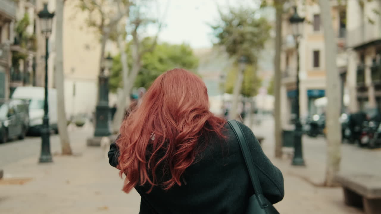 Vista de Costas de Jovem Mulher Ruiva Caminhando na Rua da Cidade