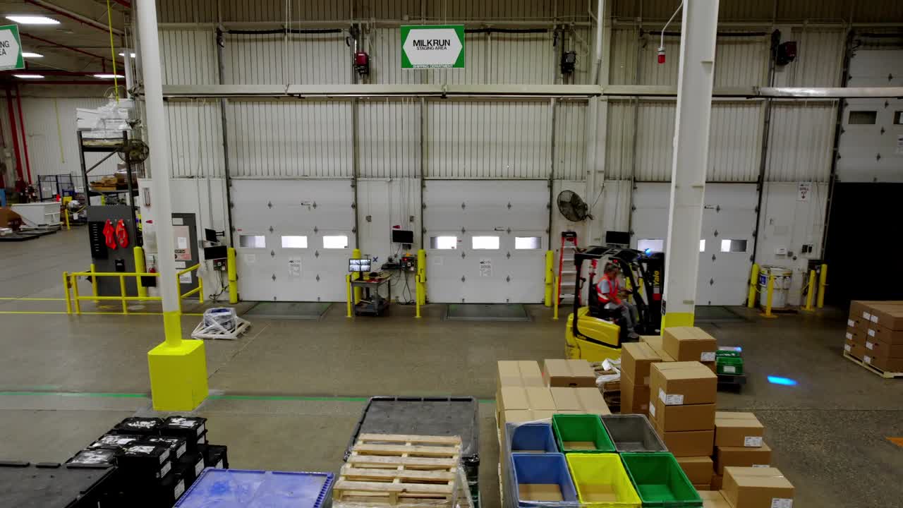 Forklift drives through GHSP factory warehouse in Michigan, wide pan