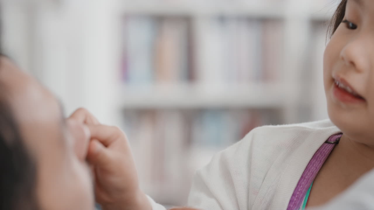 아버지와 함께 아름다운 작은 아시아 소녀가 집에서 딸과 함께 놀고 있는 가족 시간을 보내고 있습니다.