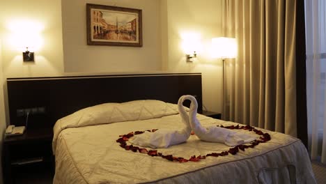 romantic hotel room with swan towels and rose petals