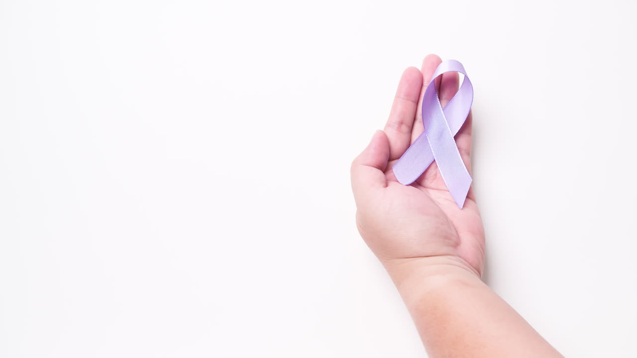 Dettaglio di una mano maschile che tiene un nastro di colore viola chiaro su sfondo bianco.