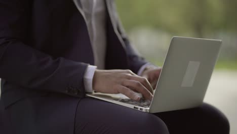 businessman typing on laptop computer outdoor