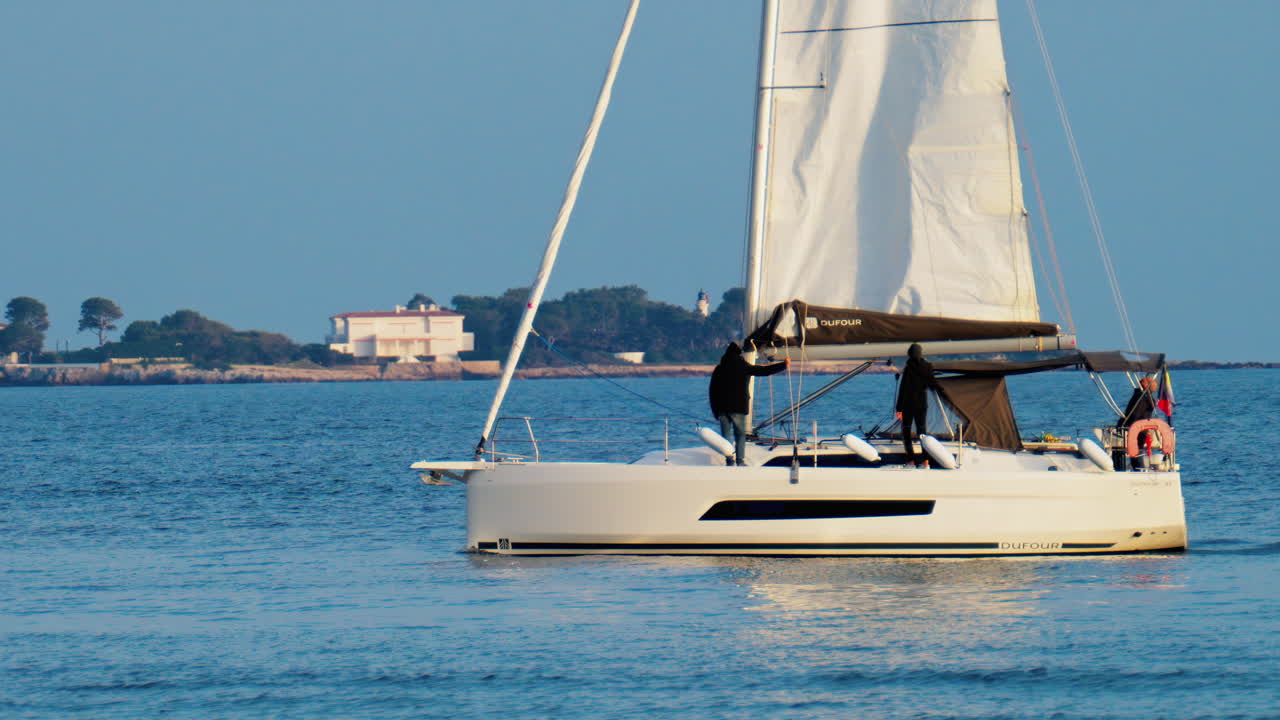 Antibes, France - February 14, 2025: People riding on a sailboat on a cloudy day