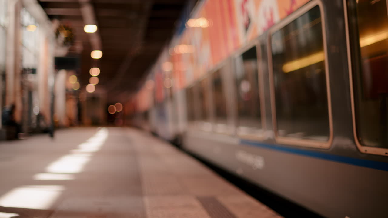 Blurred view of people moving near a train in a station
