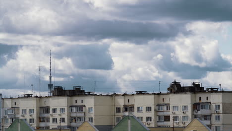 gray clouds rolling over block flats drone shot. residential area before rain.
