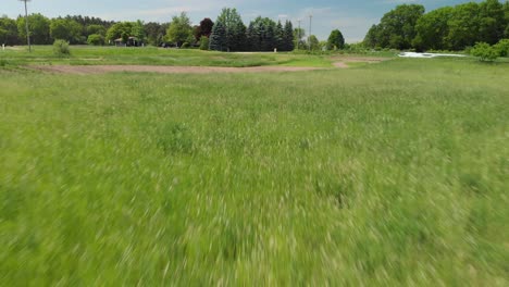 aerial drone shot flying backwards over fields of tall grass