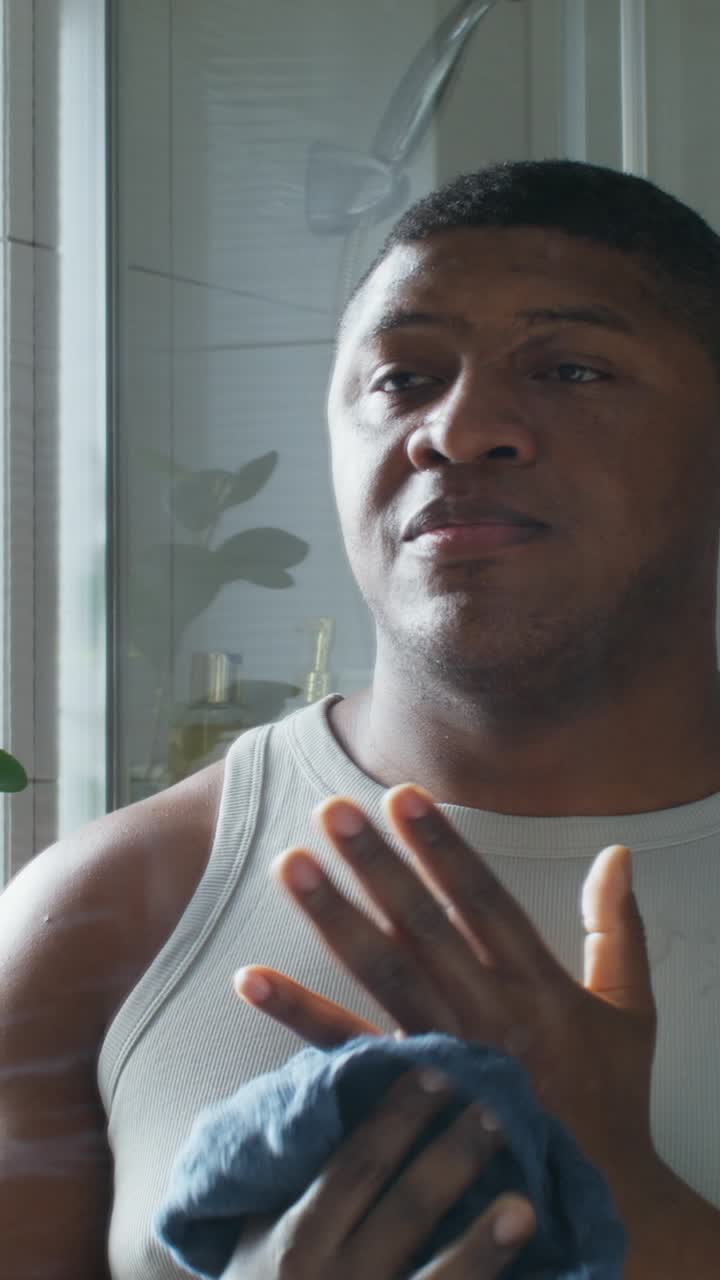 Man drying face after workout in bathroom