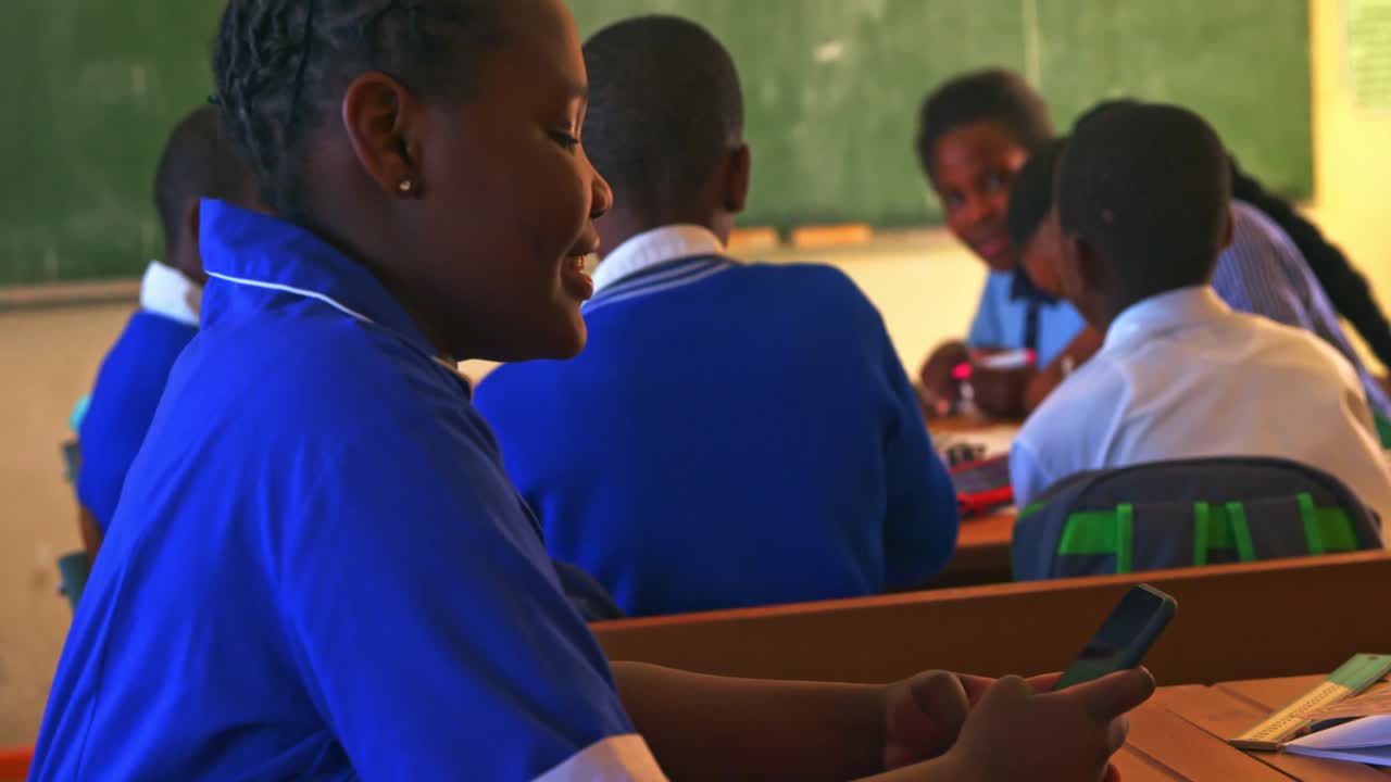 Schoolgirl using smartphone in classroom at a township school 4k