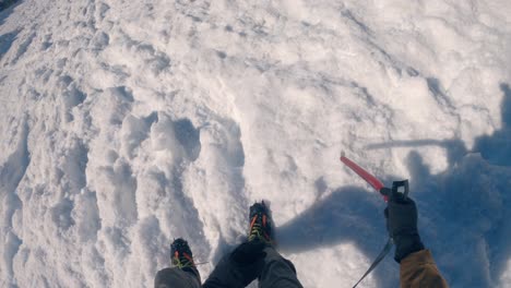 alpinist hiking down the steep and snow covered mountain - gopro on helmet view