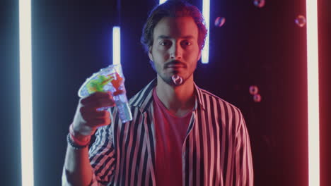 man with bubble gun under neon lights