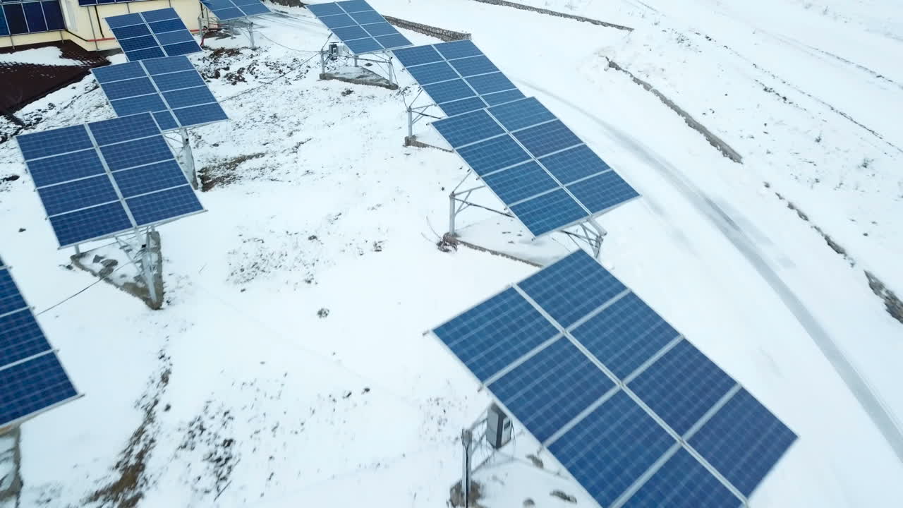 Rows of snow covered solar panels in small solar power plant. Solar power plant on the outskirts of the city.