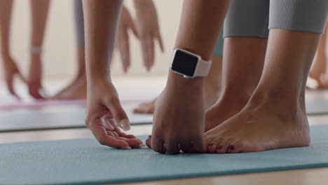 close-up-feet-yoga-class-women-stretching-practicing-half-forward-bend-pose-enjoying-fitness-studio-training-workout