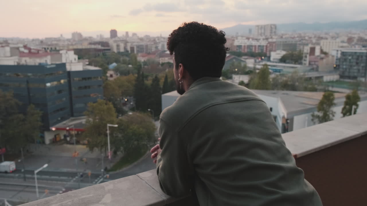 Man Contemplating City View from Rooftop