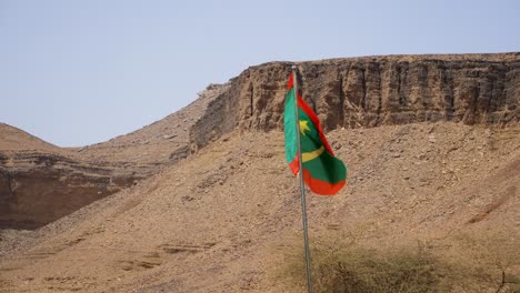 ondas de bandera de mauritania junto a los acantilados de la montaña atar en el oasis de terjit, estático