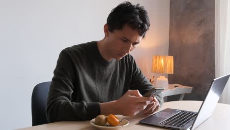 Home-office-worker-concerned-with-a-text-message-on-his-phone