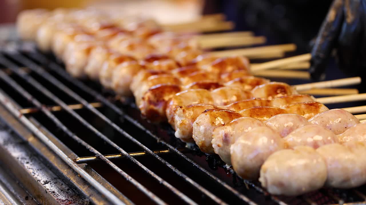 Sausages being grilled on skewers in Bangkok