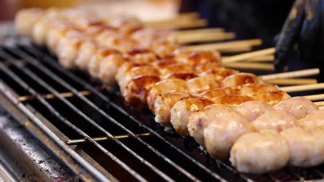 salchichas siendo asadas en broches en bangkok