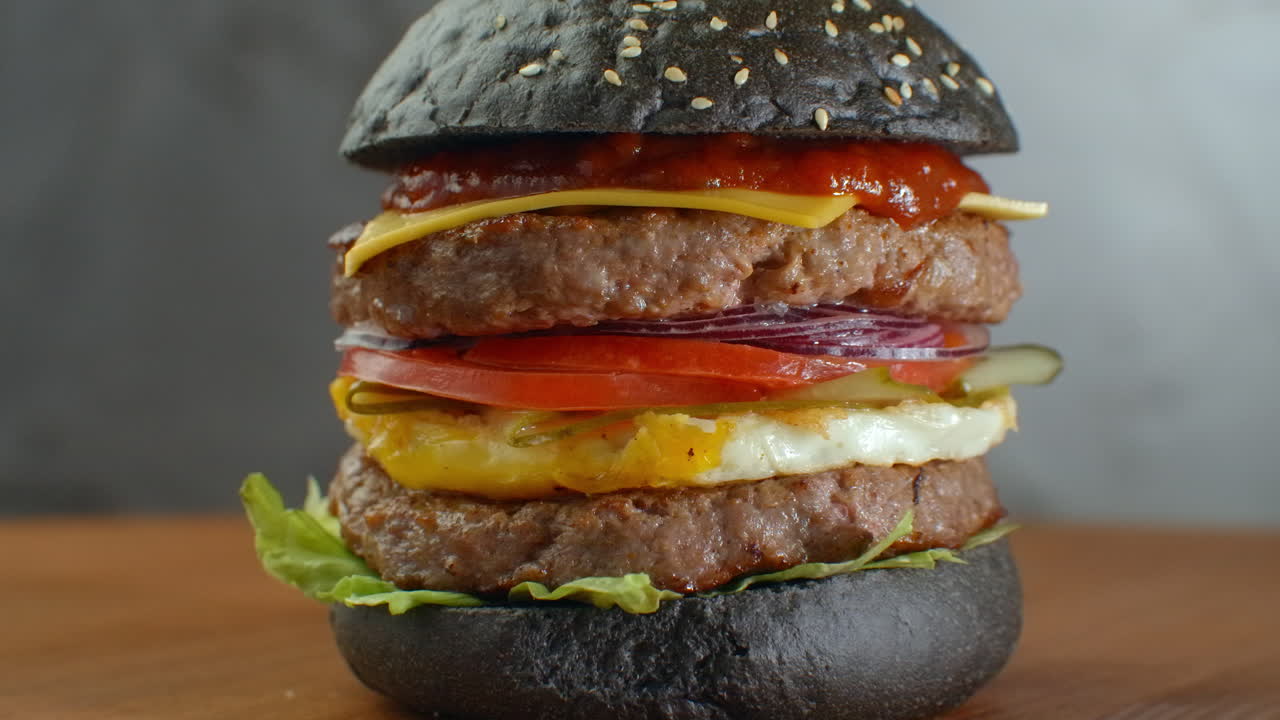 hamburguesa negra con verduras griegas hamburguesa negra en una mesa de madera