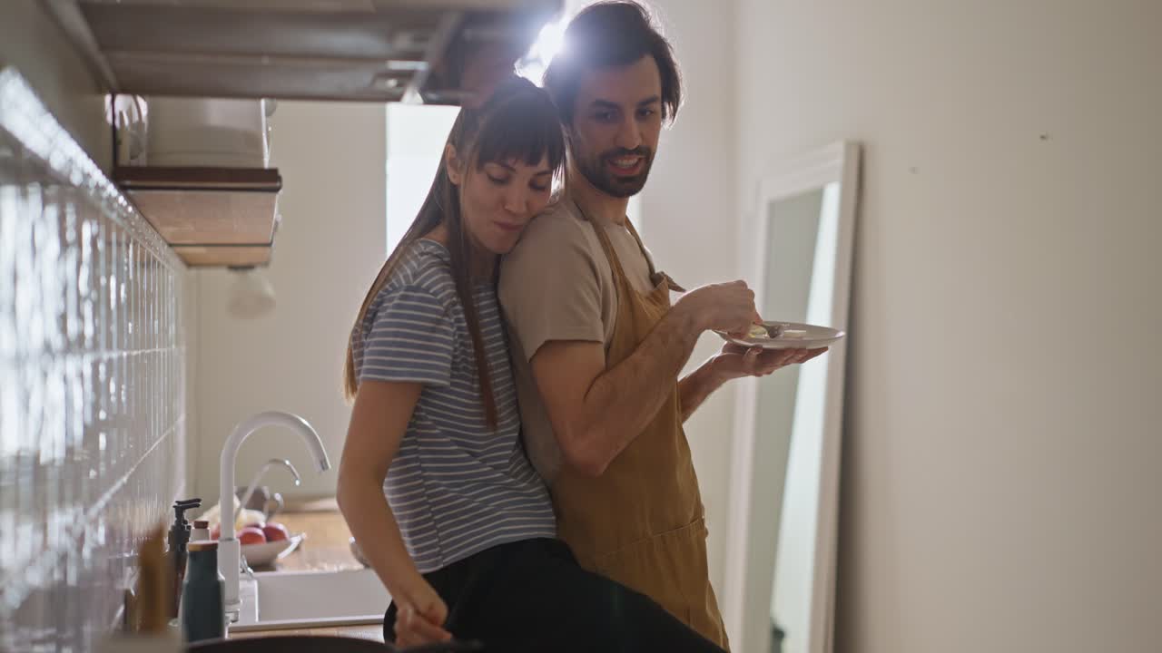Affectionate Couple Cooking Together in Kitchen