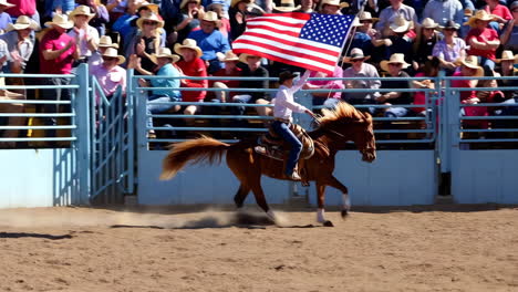 a rider on horseback carries the american flag in a rodeo arena