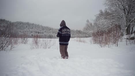 Der-Mann-Spielt-Mit-Seinem-Alaskan-Malamute-Ein-Schneeballspiel-Mitten-Im-Tiefen-Schnee---Statische-Aufnahme