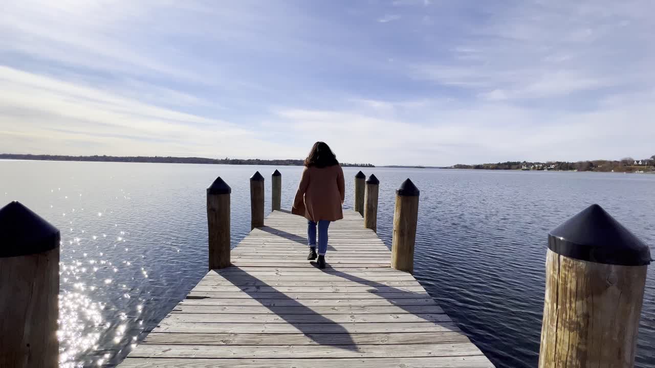 화창한 오후 동안 mjnnetonka 호수에서 보트 발사 데크를 걷고 있는 소녀
