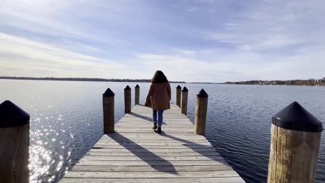 girl walking on a boat launching deck at mjnnetonka lake during a sunny afternoon