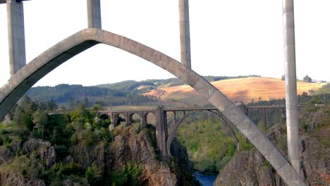 drone flying underneath the new ulla viaduct with old gundian bridge in background in galicia